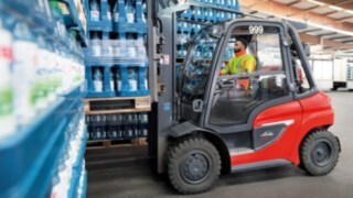 Viličar z motorjem z notranjim zgorevanjem H35 podjetja Linde Material Handling pri delu v skladišču.