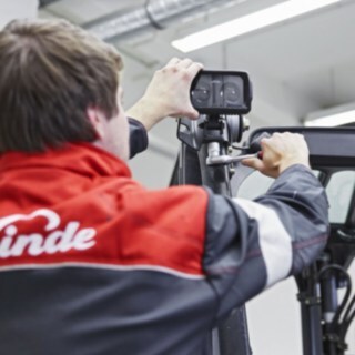 Mehanik podjetja Linde Material Handling pritrdi napravo Linde BlueSpot na streho viličarja.