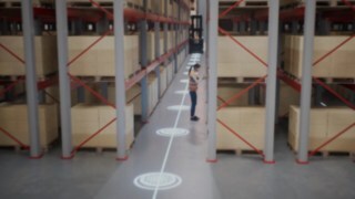 Animacija zaposlene v varnostnem jopiču v skladišču z ozkimi hodniki in varnostnih območij za prepoznavanje oseb