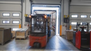 Električni viličar Linde nalaga tovornjak prek nakladalne rampe